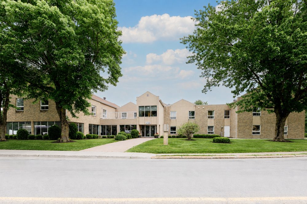 Façade de la Résidence St-Hyacinthe vue de la rue, entourée d'arbres matures.