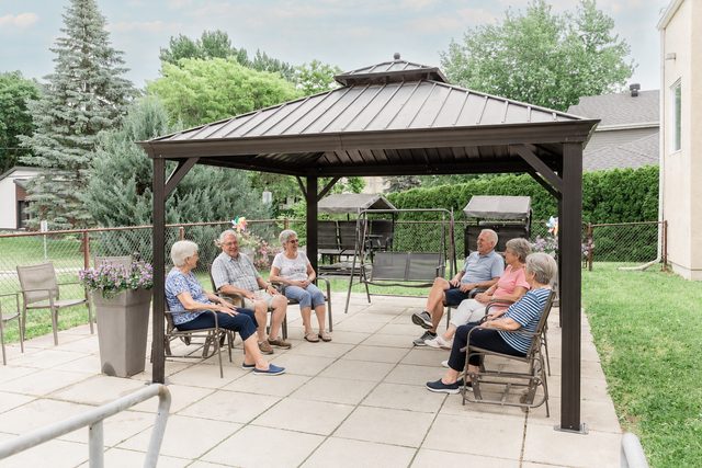 Illustration : un groupe de résidents assis sous le gazebo extérieur.